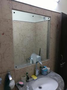a bathroom sink with a large mirror above it at Cheerful two Bedroom Green Villa by Suvana Organics in Lucknow