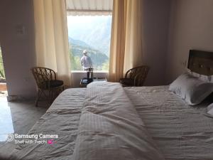 PhataKedar-Kashi Resorts and Resturant的一间卧室配有一张床,窗户配有男士