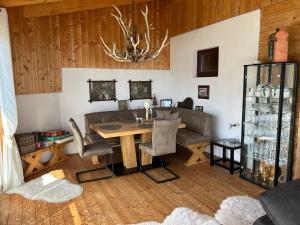 a dining room with a table and a couch at Panoramahütte Hochrindl in Hochrindl +4 photos