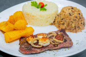 a plate of food with meat and vegetables and other foods at Raru's Motel Litoral Norte (Adult Only) in Natal +11 photos