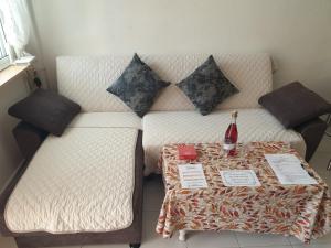 a couch with a table with a bottle of wine on it at Coqueto alojamiento en Los Alcázares in Los Alcázares