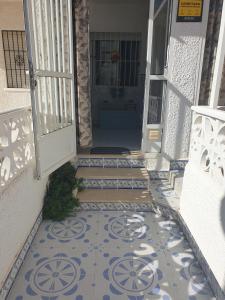 an open door with a tile floor in front of a house at Coqueto alojamiento en Los Alcázares in Los Alcázares