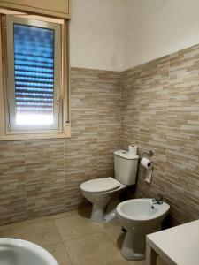 a bathroom with a toilet and a sink and a window at Bed and fly Aeroporto Catania in Catania +13 photos