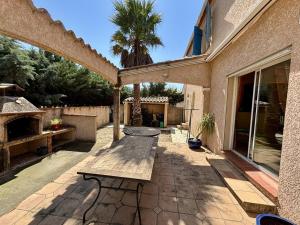 a patio with a wooden bench and a table at Villa spacieuse 3 chambres avec jardin, terrasse et garage à Argelès Village - FR-1-388-185 in Argelès-sur-Mer
