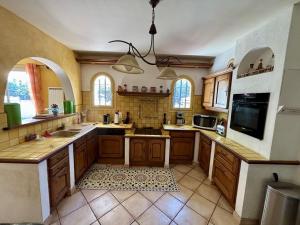 a large kitchen with wooden cabinets and a tile floor at Villa spacieuse 3 chambres avec jardin, terrasse et garage à Argelès Village - FR-1-388-185 in Argelès-sur-Mer