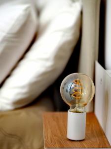 a light bulb sitting on a wooden table next to a bed at C'era una volta in Modugno
