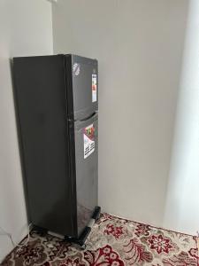 a black refrigerator in a corner of a room at Taghazout Hostel in Oulad Akkou