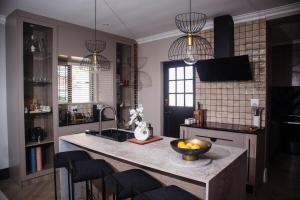 a kitchen with a island with a bowl of fruit on it at 5 On Dana in Gqeberha