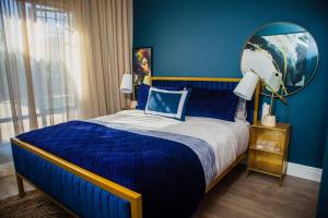 a blue bedroom with a bed and a mirror at 5 On Dana in Gqeberha +37 photos
