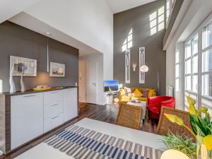 a kitchen and living room with a couch and chairs at Residenz am Balmer See - BS 71 mit Wellnessbereich in Balm