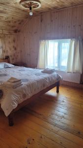 a bed in a wooden room with a window at Cabana Popas in Mărişel +33 photos