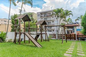 einen Spielplatz im Gras vor einem Gebäude in der Unterkunft Lindo Apto no Centro de Serra Negra in Serra Negra