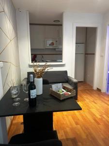 a living room with a table with a bottle of wine at Apartamentos de la Luz in Granada +27 photos
