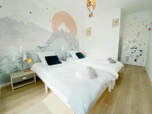 2 letti in una camera da letto con un murale di montagna sul muro di Chez Pablo, maison avec jardin et parking privé a Reims