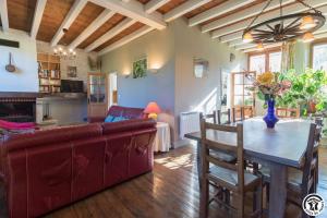 a living room with a couch and a table at Ancienne ecole in Montbrun-Bocage