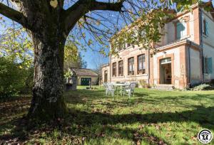 a table and chairs in front of a house at Ancienne ecole in Montbrun-Bocage