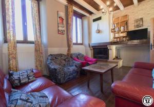 a living room with a couch and chairs and a fireplace at Ancienne ecole in Montbrun-Bocage
