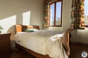 a bed in a bedroom with a window at Ancienne ecole in Montbrun-Bocage