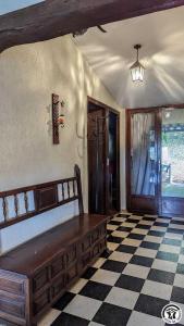 a room with a bench on a checkered floor at L'ouastadet in Aspret-Sarrat