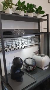a shelf with pots and pans and a toaster at Apartment A&D Home Imola Centro in Imola +13 photos