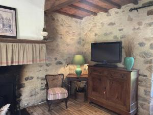 a living room with a tv and a chair at Chez pailhas in Régades