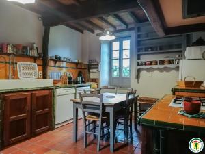 a kitchen with a table and chairs in it at Chez pailhas in Régades