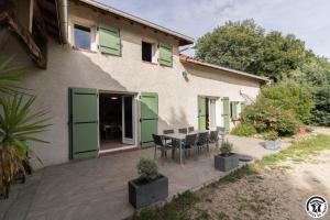 a house with a patio with a table and chairs at La lande in Ponlat-Taillebourg