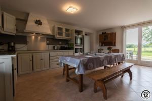 a kitchen with a table and a bench in it at La lande in Ponlat-Taillebourg