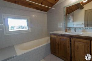 a bathroom with a tub and a sink and a mirror at La lande in Ponlat-Taillebourg +24 photos