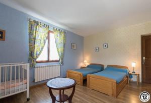 ein Schlafzimmer mit zwei Einzelbetten und einem Kinderbett in der Unterkunft Gèze in Chein-Dessus
