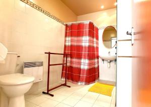 a bathroom with a toilet and a red shower curtain at Le clos saint-paul - nature in Estadens +28 photos