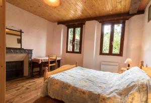 a bedroom with a bed and a fireplace and windows at Près de l'eglise in Garin