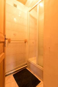 a bathroom with a shower and a black rug at Près de l'eglise in Garin