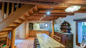 a kitchen with a long wooden table in a room at Près de l'eglise in Garin +26 photos