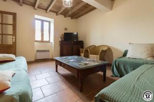 ein Wohnzimmer mit einem Tisch und zwei Betten in der Unterkunft Panifous in Montbrun-Bocage