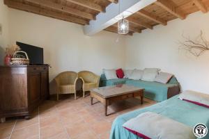 ein Wohnzimmer mit zwei Betten und einer Couch in der Unterkunft Panifous in Montbrun-Bocage