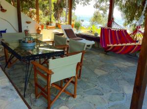 een patio met stoelen, een tafel en hangmatten bij Agrelia House in Ouranoupoli