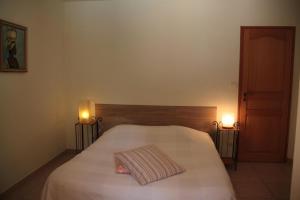 a bedroom with a white bed with two lights on it at Le petit clot de pey in Esperce