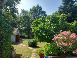 a garden with flowers and plants in front of a house at Le petit clot de pey in Esperce +3 photos