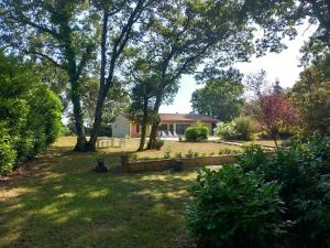 a house with a yard with a fence and trees at Le petit clot de pey in Esperce