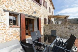 a patio with a glass table and chairs on a building at Le volp in Le Plan