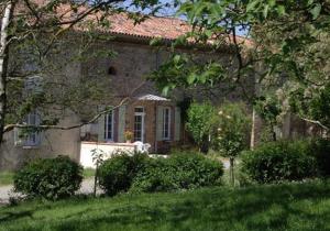a large stone house with a yard with bushes at Chantecler in Pibrac