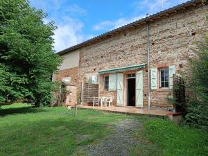 a brick house with a porch with a table on it at Granny in Pibrac