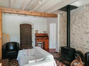 a living room with a couch and a stove at Le gar in Labarthe-Rivière