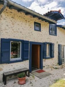 a house with blue shuttered windows and a door at Le gar in Labarthe-Rivière