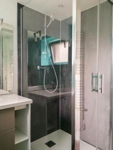 a bathroom with a shower with a glass door at Le gar in Labarthe-Rivière