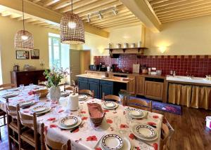 a dining room with a table and a kitchen at Le clos saint-paul - comminges in Estadens