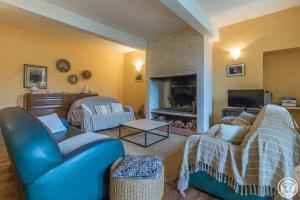 a living room with blue chairs and a fireplace at Le clos saint-paul - comminges in Estadens