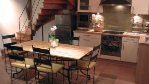 a kitchen with a wooden table and chairs and a staircase at Baugnac in Lavalette