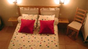 a bedroom with a bed with two red pillows at Baugnac in Lavalette